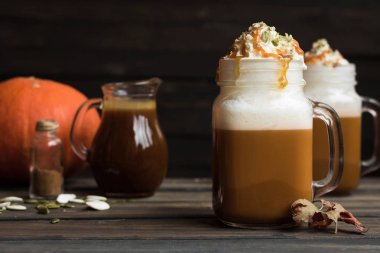 Baharat ve krem şanti bir kap ile baharatlı Sütlü Balkabağı tuzlu karamel ile dekore edilmiş ve kabak çekirdeği ezilmiş