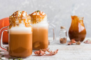 Baharat ve krem şanti bir kap ile baharatlı Sütlü Balkabağı tuzlu karamel ile dekore edilmiş ve kabak çekirdeği ezilmiş