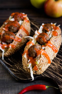 Apple ve lahana ile köfte ile baharatlı sosisli karanlık bir arka plan üzerinde garnitür