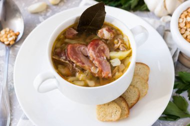 Geleneksel ev yapımı kalın bezelye çorbası bir aile akşam yemeği için beyaz bir tabak içinde füme et