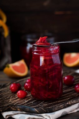 Baharatlı kızılcık-portakal sosu koyu ahşap arka plan üzerinde et için