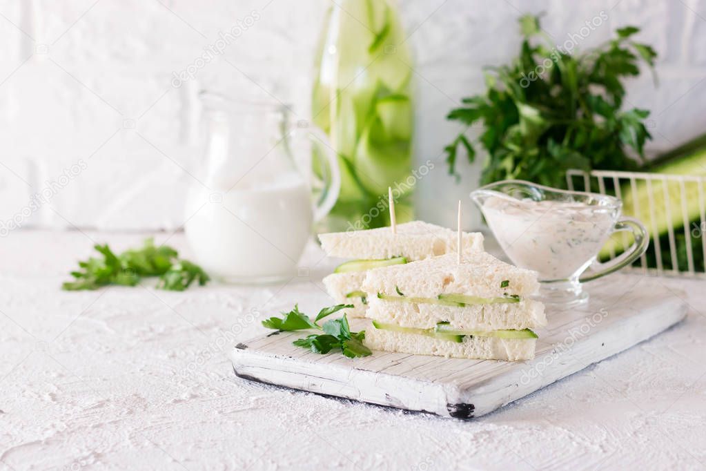 Summer snack three-layer sandwich with cucumber and yogurt sauce with parsley