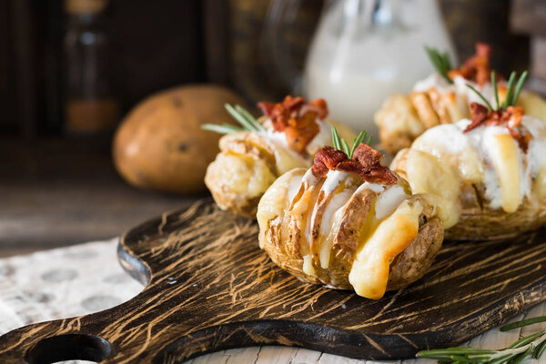 Appetizer of baked potatoes with bacon and fresh yogurt