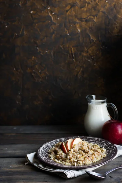 Гречневая каша с молоком, яблоком, изюмом и орехами кешью — стоковое фото