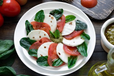 Tahıllı ekmek üzerinde pesto ve balsamik sirke ile Caprese salatası