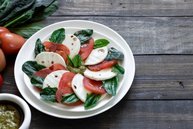 Tahıllı ekmek üzerinde pesto ve balsamik sirke ile Caprese salatası