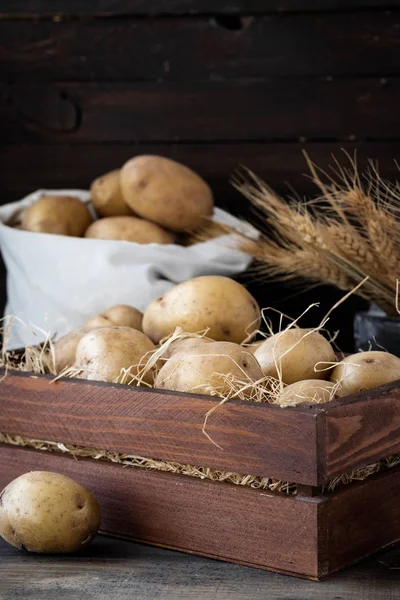 Органический сырой картофель в деревянном ящике в Соломе — стоковое фото