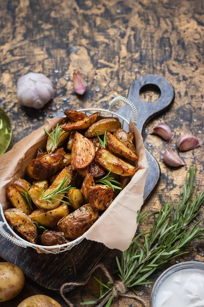 Patatas jóvenes al horno en un estilo rústico con crema agria — Foto de Stock