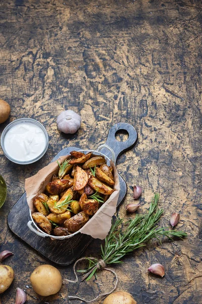 Patatas jóvenes al horno en un estilo rústico con crema agria — Foto de Stock