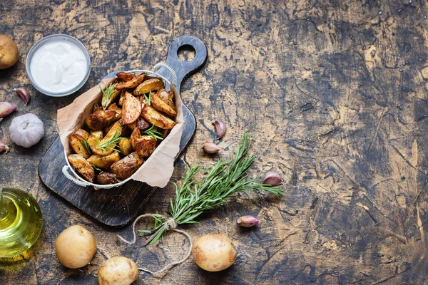 Patatas jóvenes al horno en un estilo rústico con crema agria — Foto de Stock