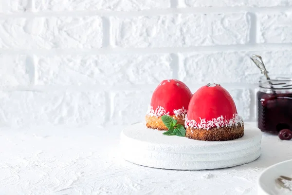 Torta di mousse con glassa a specchio e ripieno di ciliegie su un cuscino di biscotti al cocco — Foto Stock