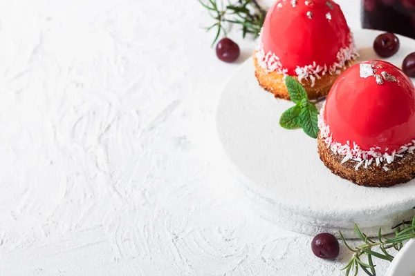 Pastel de mousse con esmalte de espejo y relleno de cereza en una almohada de galletas de coco Fotos De Stock