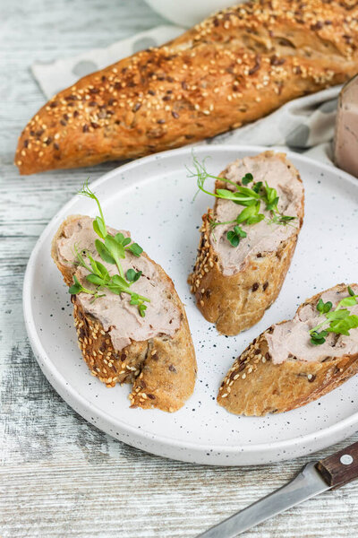 Turkey liver pate on a whole grain baguette with pea sprouts. A simple and comfortable snack