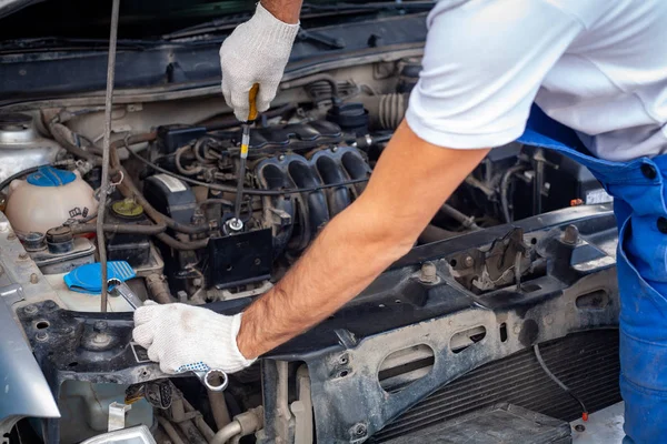 Mechaniker mit Schraubenschlüssel repariert Auto-Motor bei — Stockfoto