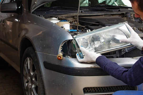 The mechanic sets the spotlight on car — Stock Photo, Image