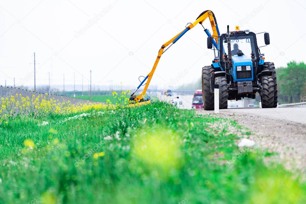 Tractor with a mechanical mower mowing grass