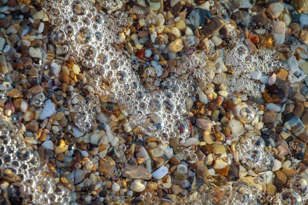 海の小石は ビーチの背景石に花崗岩を着色しました 海の波に洗われた砂と小石のビーチの海岸 — ストック写真