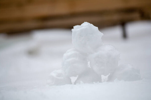 real snowballs with their hands clasped from the fresh snow in winter on the street