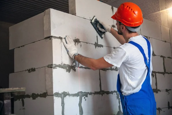 先生は家を建てるときにコンクリートブロックの壁を置きます 民間住宅建設 航空コンクリートブロックの建設のための近代的な技術と材料 — ストック写真
