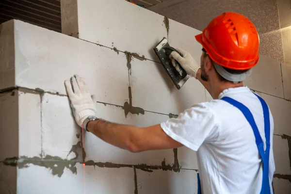 Mason alinhando bloco de concreto autoclavado aerado da parede da casa construída — Fotografia de Stock