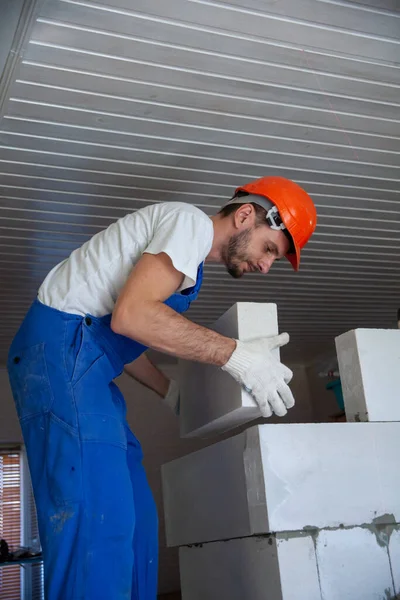 Mason aligning aerated autoclaved concrete block of constructed house wall — Stock Image Mason aligning aerated autoclaved concrete block of constructed house wall Stock Image