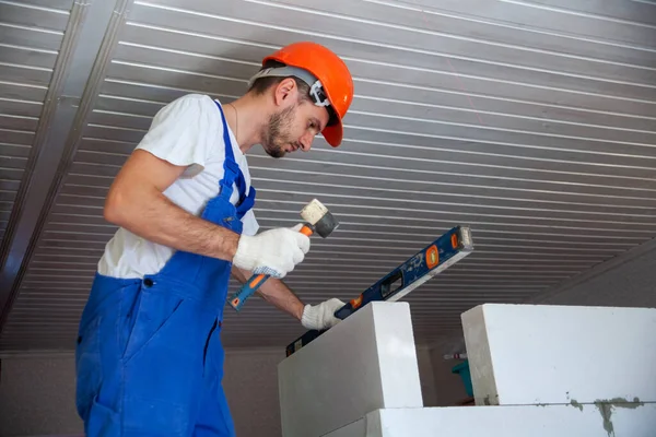 Mason aligning aerated autoclaved concrete block of constructed house wall — Stock Image Mason aligning aerated autoclaved concrete block of constructed house wall Stock Photo