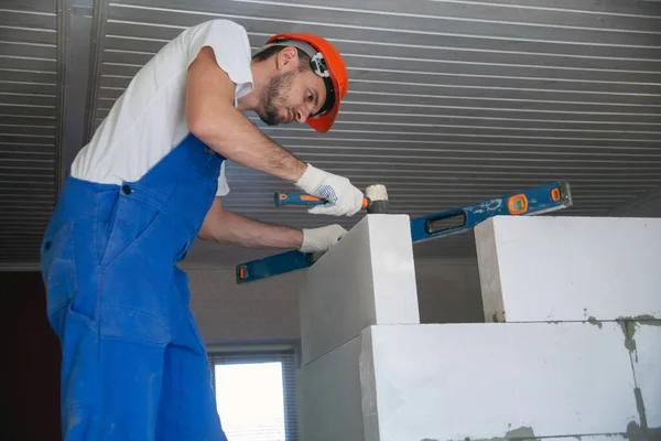 Mason aligning aerated autoclaved concrete block of constructed house wall — Stock Image Mason aligning aerated autoclaved concrete block of constructed house wall Stock Image