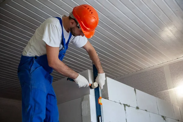 Mason aligning aerated autoclaved concrete block of constructed house wall — Stock Image Mason aligning aerated autoclaved concrete block of constructed house wall Royalty Free Stock Photos