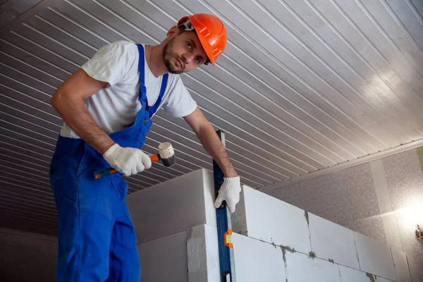 Mason aligning aerated autoclaved concrete block of constructed house wall — Stock Image Mason aligning aerated autoclaved concrete block of constructed house wall Stock Picture