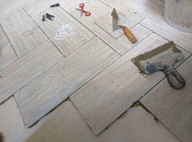 Tuğlacı porselen bir taş döşeme yerleştiriyor.