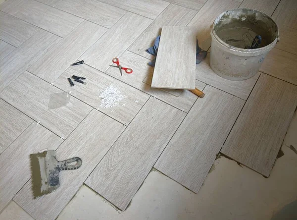 Bricklayer placing a porcelain stoneware floor — Stock Photo, Image