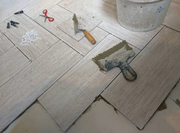 Tuğlacı porselen bir taş döşeme yerleştiriyor.