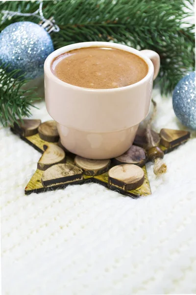 Una taza de café caliente en un soporte de madera en forma de estrella sobre una tela blanca a cuadros con cubos de abeto y decoraciones navideñas con espacio para copiar — Foto de Stock