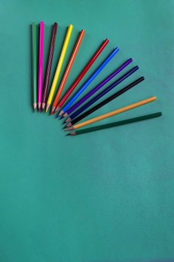 Metin için kopya alanı ile bir kağıt koyu mavi arka plan üzerinde renkli ahşap kalemler. Okul ekipmanları. Düz yatıyordu