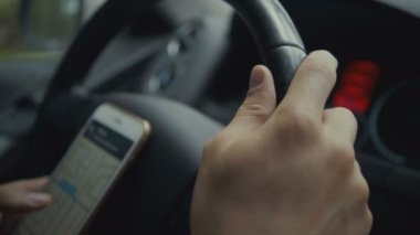harita app onun akıllı bir araba kullanan genç adam. Görüntüleri genç sürücü tekerlek behind.
