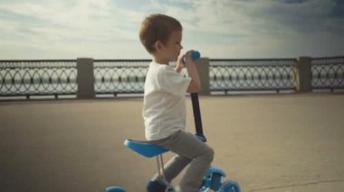 Bir yaz parkta bir scooter sürme mutlu küçük çocuk iki yaşında,