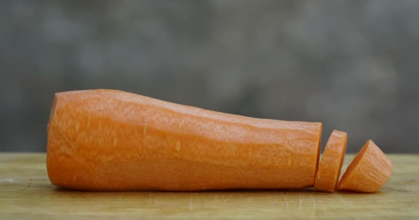 Подрібнення моркви крупним планом на дерев'яній дошці . — стокове відео