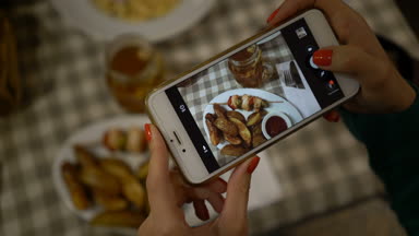 smartphone ve sosyal ağlar için gıda alarak fotoğraf holding eller, yakın çekim