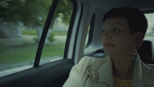 Donna che guida in auto attraverso la città durante la giornata di sole . — Video Stock