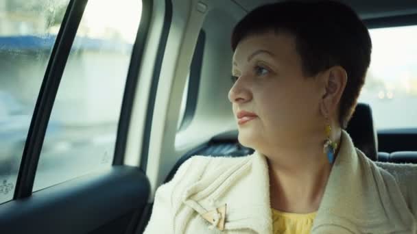 Woman riding in car through city during sunny day. — Stock Video