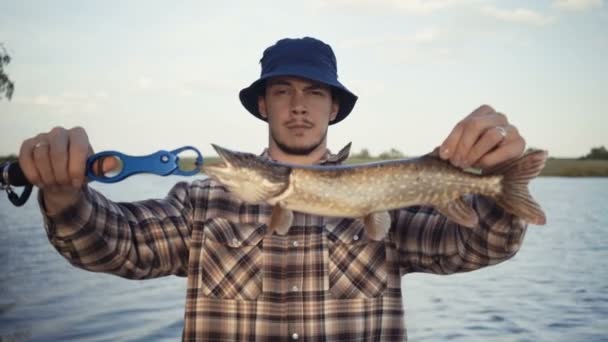 Jovem pescador pesca ativa no lago — Vídeo de Stock