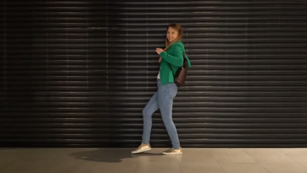 Mladá dívka v pohybu a emocí na pozadí kovové textury. — Stock video