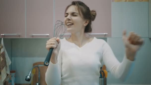 Забавная домохозяйка поет и танцует на кухне . — стоковое видео