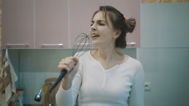 Grappige huisvrouw zingen en dansen in de keuken. — Stockvideo