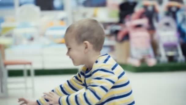 Little boy in the supermarket choose a bottle of mineral water. — Stock Video
