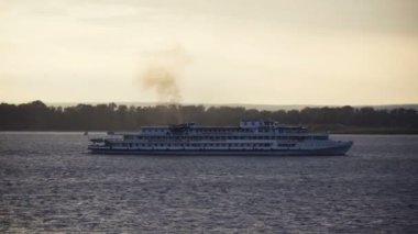 gün batımı bir arka plan üzerinde nehrin tekne yüzen.