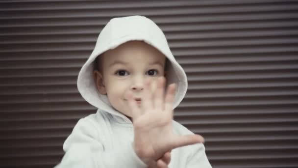 Portret van een jongen van twee jaar op een achtergrond van bruin texturen. — Stockvideo