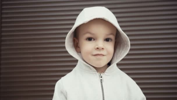 Porträtt av en pojke på två år på en bakgrund av brun texturer. — Stockvideo