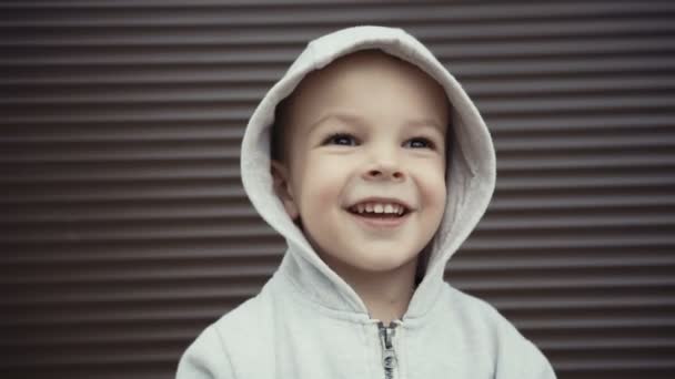 Porträtt av en pojke på två år på en bakgrund av brun texturer. — Stockvideo