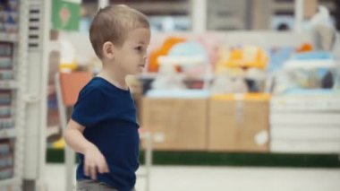 Küçük çocuk marketteki seçin bir şişe maden suyu.